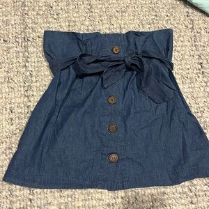 Denim miniskirt with buttons and waist tie.
